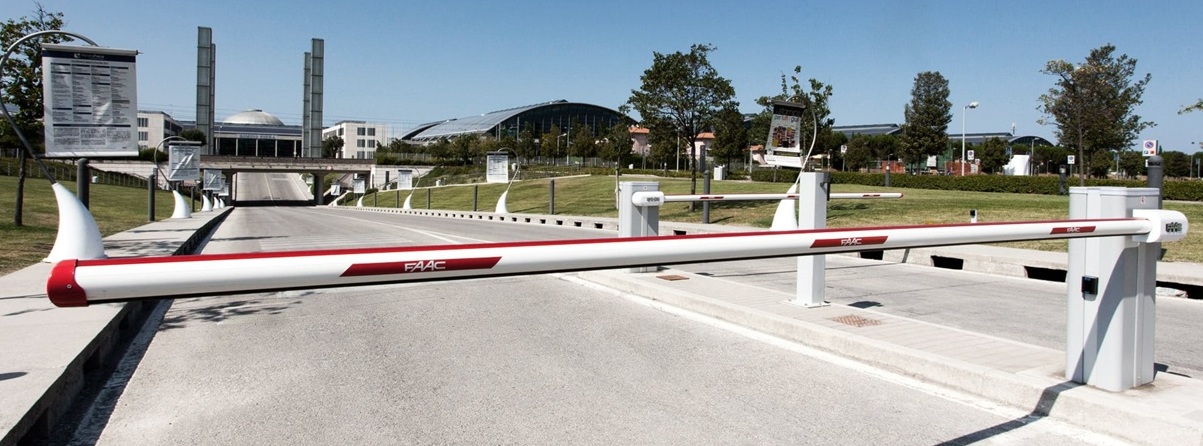 FAAC B680H automatic barrier gates installed on center median controlling two-way traffic on wide industrial roadway